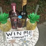 a small table with bottles of alcohol and a sign that says "WIn Me"